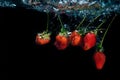 Strawberry dropped into water with splash on black backgro Royalty Free Stock Photo