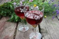 Strawberry elderflower cocktail, and wild blue and yellow flowers on the wooden board table. Two glasses of red wine with berries Royalty Free Stock Photo