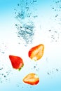 Strawberry are falling in water with a big splash Royalty Free Stock Photo