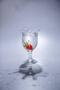 The strawberry falls into a glass of water Royalty Free Stock Photo