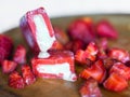 Strawberry-flavored icecreams and fresh strawberries on a wooden board