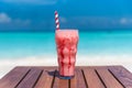 Strawberry Frappuccino drink with straw on wooden table ocean background at the beach