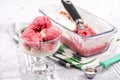 Strawberry frozen yogurt in glass bowl, ice cream balls, container with homemade sundae Royalty Free Stock Photo