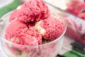 Strawberry frozen yogurt in glass bowl, ice cream balls, container with homemade sundae Royalty Free Stock Photo
