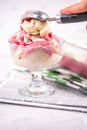 Strawberry frozen yogurt in glass bowl, ice cream balls, container with homemade sundae Royalty Free Stock Photo