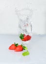 Strawberry fruit drops onto a wine glass, freeze motion of the water splash, white background Royalty Free Stock Photo