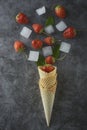 Strawberry fruits in waffle cone, over dark background, top view Royalty Free Stock Photo