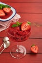 Strawberry granita or fresh berry sorbet in glass on old red wooden table background. Texture of ice cream or sorbet. Ice cream Royalty Free Stock Photo