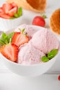 Strawberry ice cream with fresh berries in a bowl on a white wooden background. Selective focus Royalty Free Stock Photo