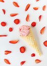 Strawberry ice cream in a waffle cup in the form of a cone, ice cream lies on a white table along with slices of fresh Royalty Free Stock Photo