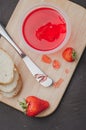 Strawberry jam. Bread and strawberry jam on a dark stone background with jar of jam and fresh strawberry. Top view. Making Royalty Free Stock Photo