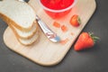 Strawberry jam. Bread and strawberry jam on a dark stone background with jar of jam and fresh strawberry. Top view. Making Royalty Free Stock Photo