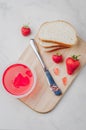 Strawberry jam. Bread and strawberry jam on a wooden table with jar of jam and fresh strawberry. Making sandwiches with strawberry Royalty Free Stock Photo