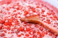 Strawberry jam cooking process. Wooden spoon liying on jam surface. Organic traditional jam manufacturing