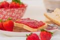 Strawberry jam, fresh strawberries and knife on a plate