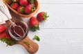 Strawberry jam. Strawberry jam in glass jar with fresh berries plate on white wooden table background, closeup. Homemade Royalty Free Stock Photo