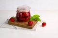 Strawberry jam in a glass jar with fresh berries on white wooden background. Homemade strawberry marmelade. Royalty Free Stock Photo