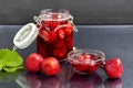 Strawberry jam in a glass jar next to fresh strawberries. On a black wooden background. Homemade winter fruit blanks. Selective Royalty Free Stock Photo