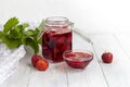 Strawberry jam in a glass jar next to fresh strawberries. On a white wooden background. Homemade winter fruit blanks. Selective Royalty Free Stock Photo