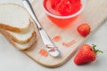 Strawberry jam. Making sandwiches with strawberry jam. Bread and strawberry jam on a white table with jar of jam and fresh Royalty Free Stock Photo