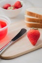 Strawberry jam. Making sandwiches with strawberry jam. Bread and strawberry jam on a white table with jar of jam and fresh Royalty Free Stock Photo