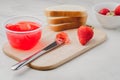 Strawberry jam. Making sandwiches with strawberry jam. Bread and strawberry jam on a white table with jar of jam and fresh Royalty Free Stock Photo