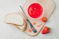 Strawberry jam. Making sandwiches with strawberry jam. Top view. Bread and strawberry jam on a white table with jar of jam and Royalty Free Stock Photo