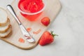 Strawberry jam. Making sandwiches with strawberry jam. Top view. Bread and strawberry jam on a white table with jar of jam and Royalty Free Stock Photo