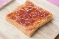 Strawberry jam spread on bread on wooden plate Royalty Free Stock Photo