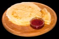 Strawberry jam on a stack of pancakes. Russian blini on black b