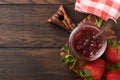 Strawberry jam. Strawberry jam in glass jar with fresh berries plate on an old wooden dark table background, closeup. Homemade str Royalty Free Stock Photo