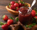 Strawberry jam. Strawberry jam in glass jar with fresh berries plate on an old wooden dark table background, closeup. Homemade str Royalty Free Stock Photo