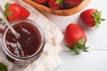 Strawberry jam. Strawberry jam in glass jar with fresh berries plate on white wooden table background, closeup. Homemade Royalty Free Stock Photo