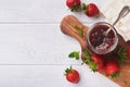 Strawberry jam. Strawberry jam in glass jar with fresh berries plate on white wooden table background, closeup. Homemade Royalty Free Stock Photo