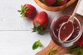 Strawberry jam. Strawberry jam in glass jar with fresh berries plate on white wooden table background, closeup. Homemade Royalty Free Stock Photo