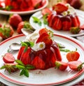 Strawberry jelly with the addition of halfs of fresh strawberries and mint leaves on a white plate. Royalty Free Stock Photo