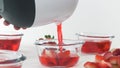 Strawberry Jelly Preparation Process. Strawberry Slices in a Glass Bowls. Pouring Jelly Mix in a Bowls. Close Up Top View on Whit Royalty Free Stock Photo