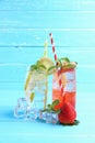 Strawberry juice and lemon juice mixing soda no alcohol in the glass garnish with mint leaves, sliced lime on blue wooden table Royalty Free Stock Photo