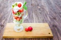 Strawberry layered dessert with fresh strawberries and cream cheese on wooden table over green garden background Royalty Free Stock Photo