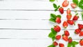 Strawberry with leaves on a white wooden background. Berries Top view.