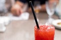 Strawberry lemonade pouring in glass from jug. Cocktail with strawberry, ice and mint in glasses on white concrete background, Royalty Free Stock Photo