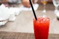 Strawberry lemonade pouring in glass from jug. Cocktail with strawberry, ice and mint in glasses on white concrete background, Royalty Free Stock Photo