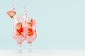 Strawberry lemonade with ripe berry slices, ice cubes and mineral water, straw in elegant glass on white wood table, mint color. Royalty Free Stock Photo