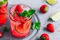 Strawberry lime lemonade with fresh mint and ice in glass jar