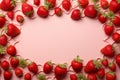 Strawberry made frame on soft pink backdrop with vibrant red charm