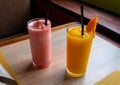 Strawberry mango shake on wooden table. Orange and pink fruit shake photo. Refreshing fruit drink. Vegetarian dessert Royalty Free Stock Photo