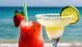 strawberry margarita and Daiquiri frozen and on ice with lime and berry fruit at beach side for summer time relaxation in the sun Royalty Free Stock Photo