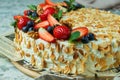 Strawberry meringue cake with almond petals, on newspaper Royalty Free Stock Photo