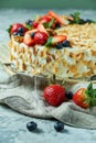 Strawberry meringue cake with almond petals, on newspaper Royalty Free Stock Photo