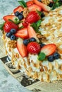 Strawberry meringue cake with almond petals, on newspaper Royalty Free Stock Photo
